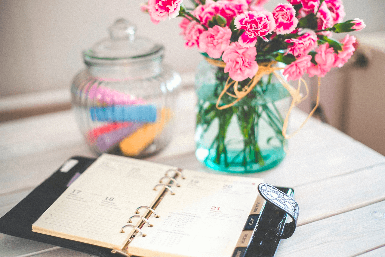 Image of a daily calendar on a table with fresh flowers