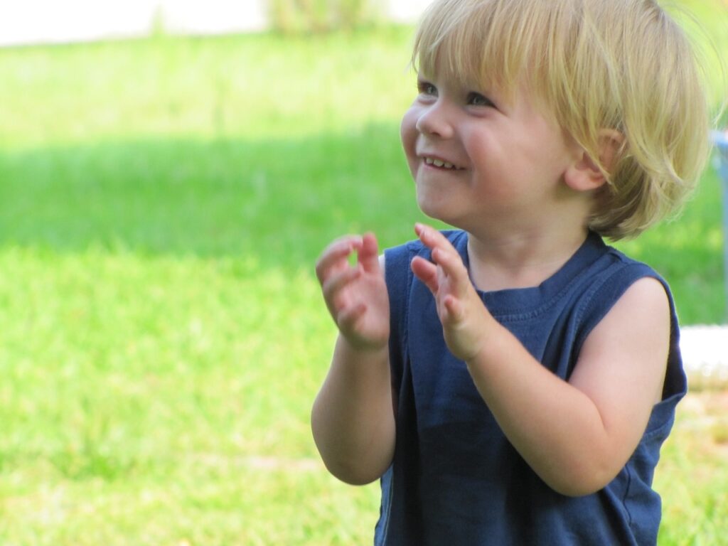 This is an image of a child smiling outside.