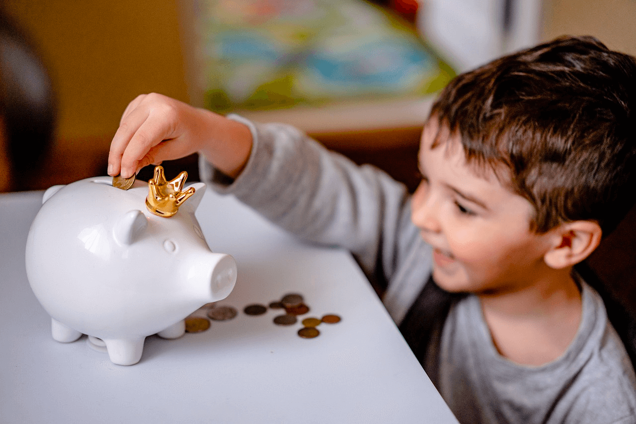 Image of a happy boy with a piggy bank